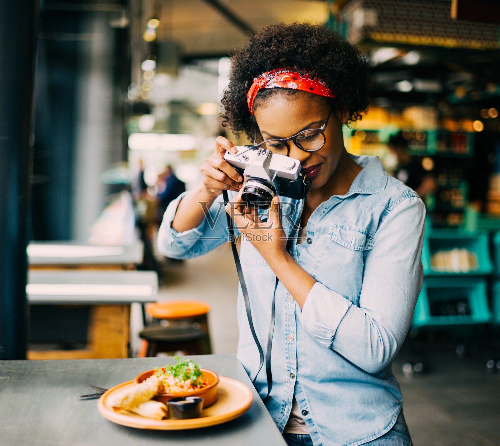 一名年轻女子在咖啡馆柜台上拍摄她的食物照片摄影图片