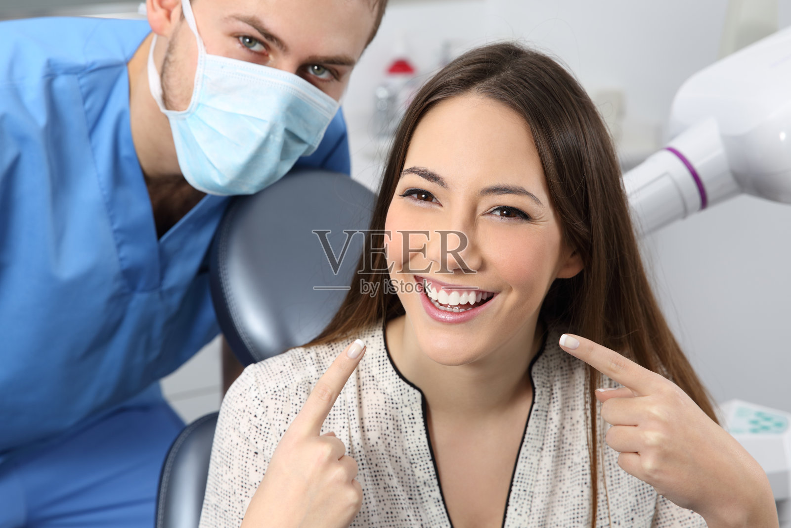 满意的牙医病人展示她完美的微笑照片摄影图片