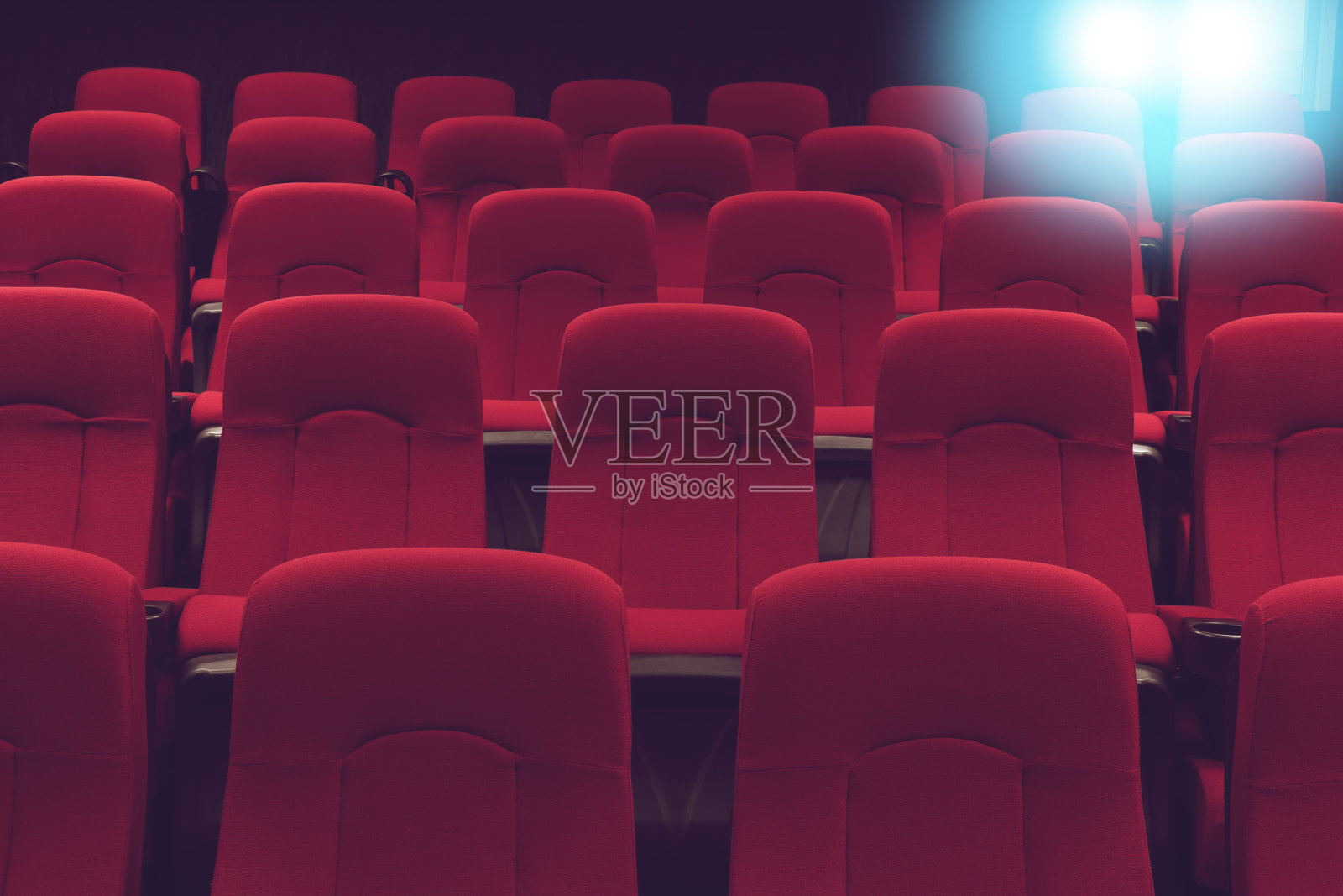 电影院空荡荡的礼堂，红色的座位和蓝色的灯光照片摄影图片