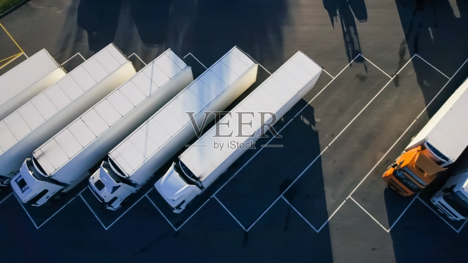 空中鸟瞰图的白色半挂车与其他车辆在特殊停车场。照片摄影图片
