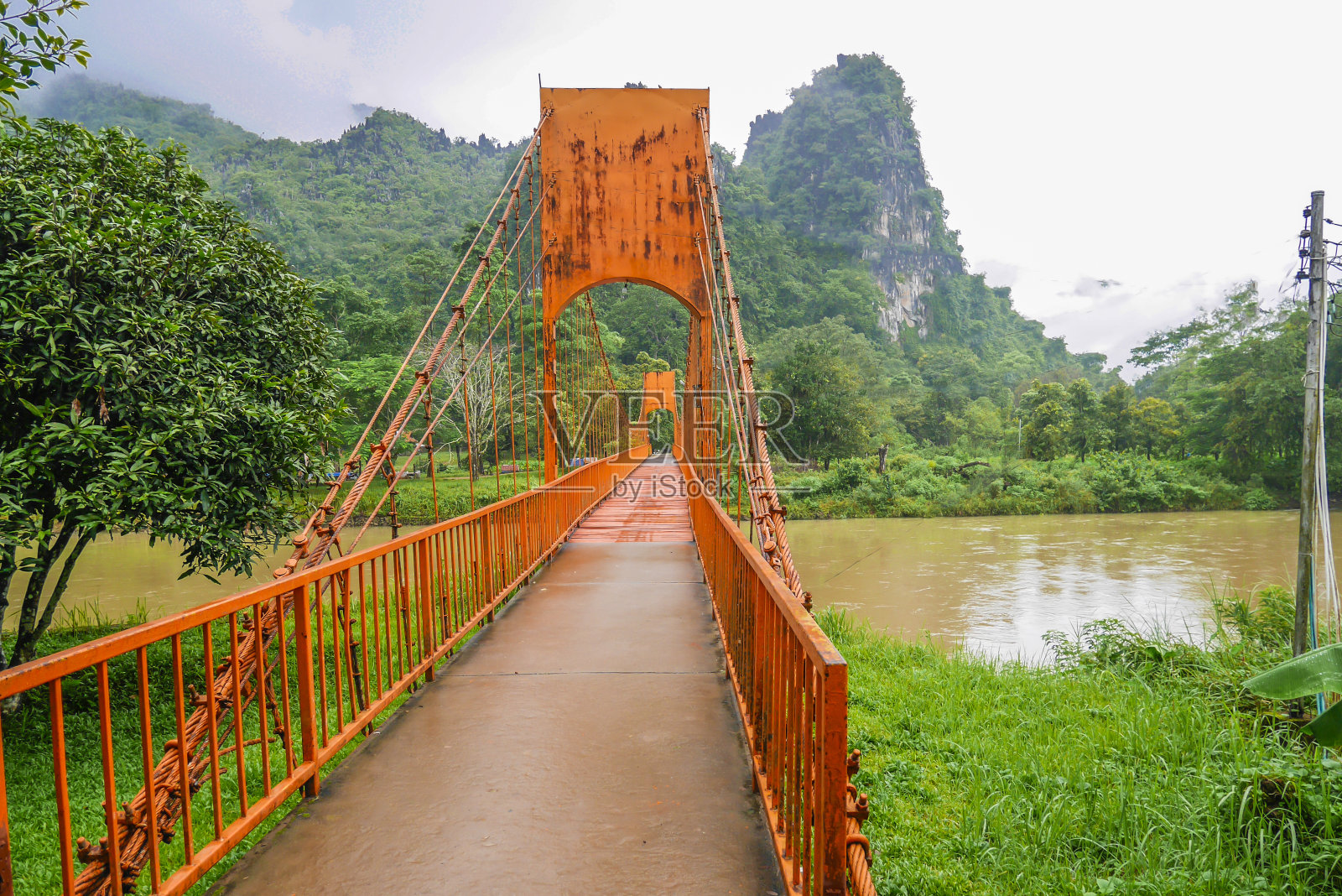 老挝万荣的一座横跨宋河的橙色桥。照片摄影图片
