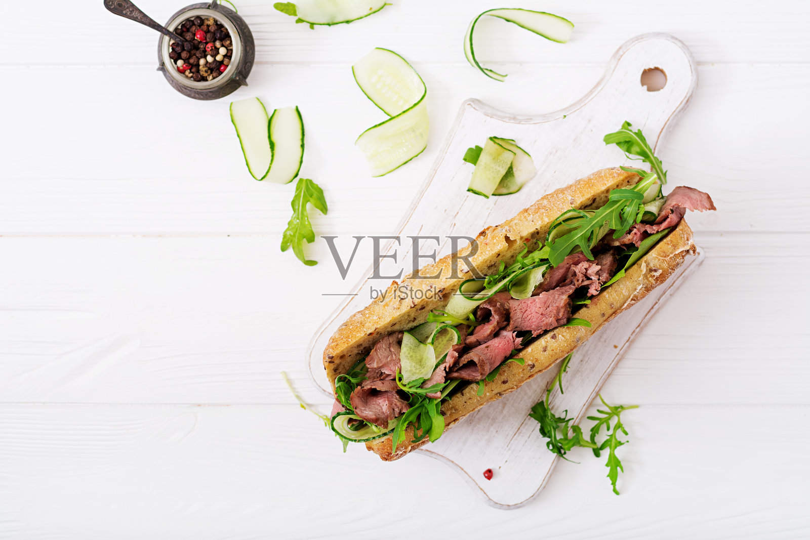 全麦面包三明治配烤牛肉，黄瓜和芝麻菜。前视图。平躺照片摄影图片