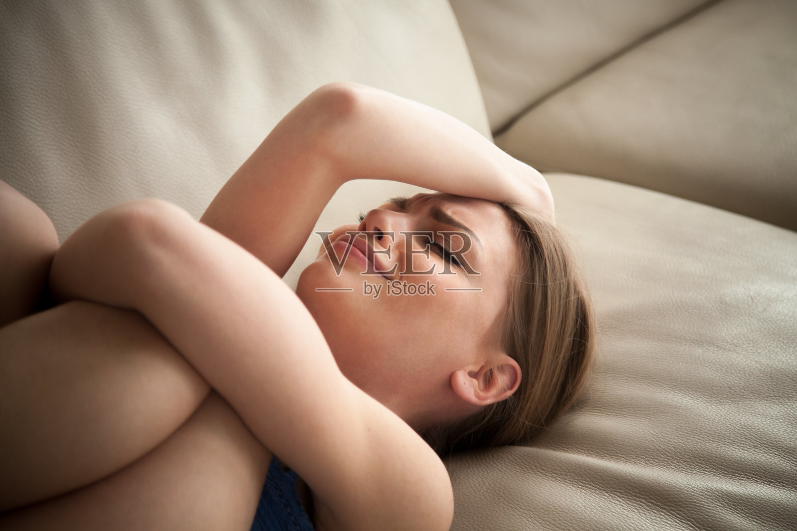 压力山大的女人躺在家里的沙发上哭照片摄影图片
