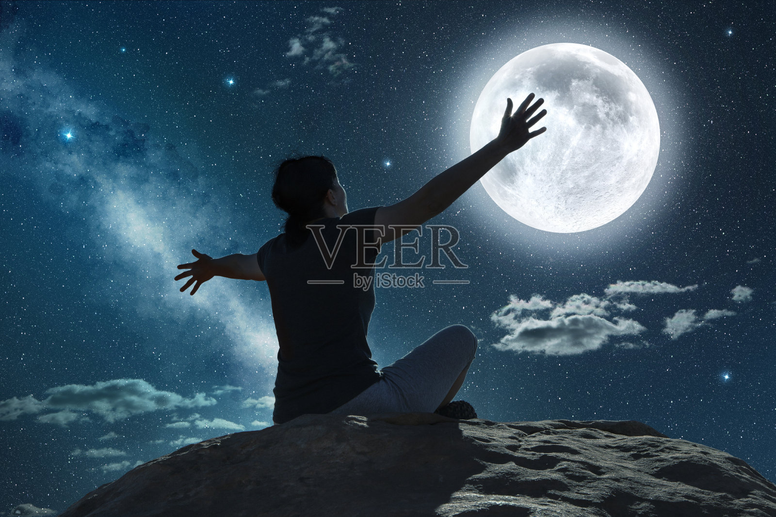 在月光下举起手臂的女人照片摄影图片