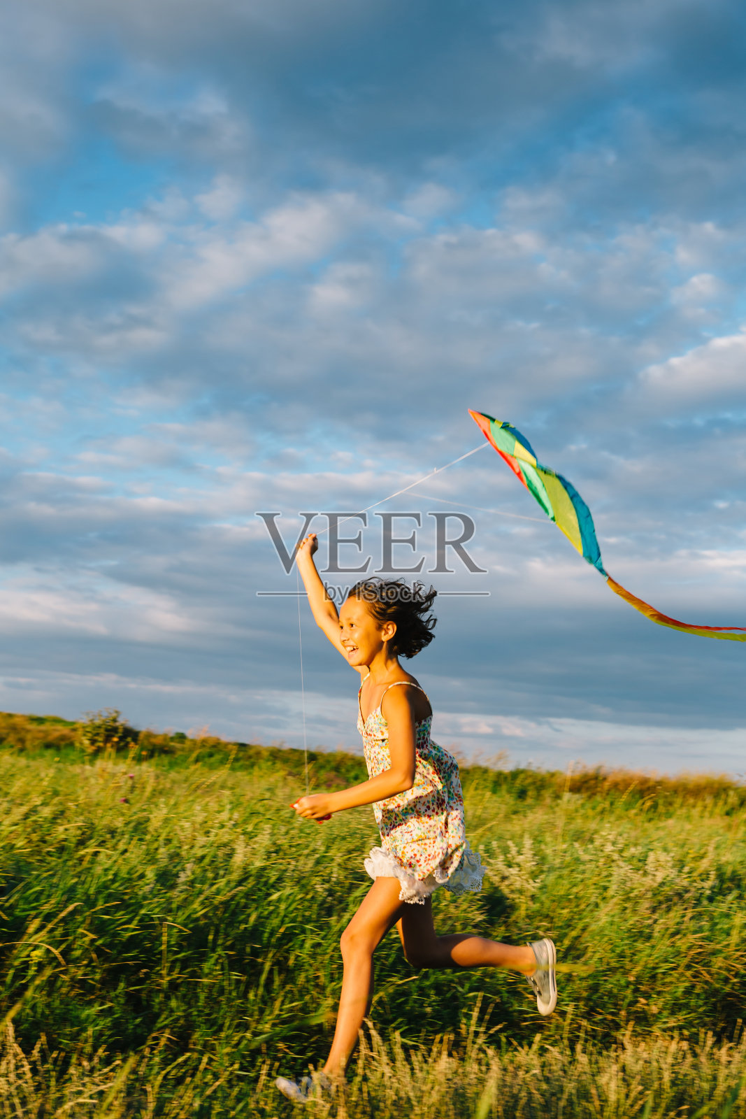 快乐的女孩拿着风筝跑照片摄影图片