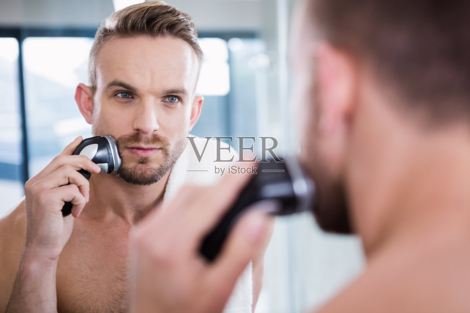 专心剃胡须的男人照片摄影图片