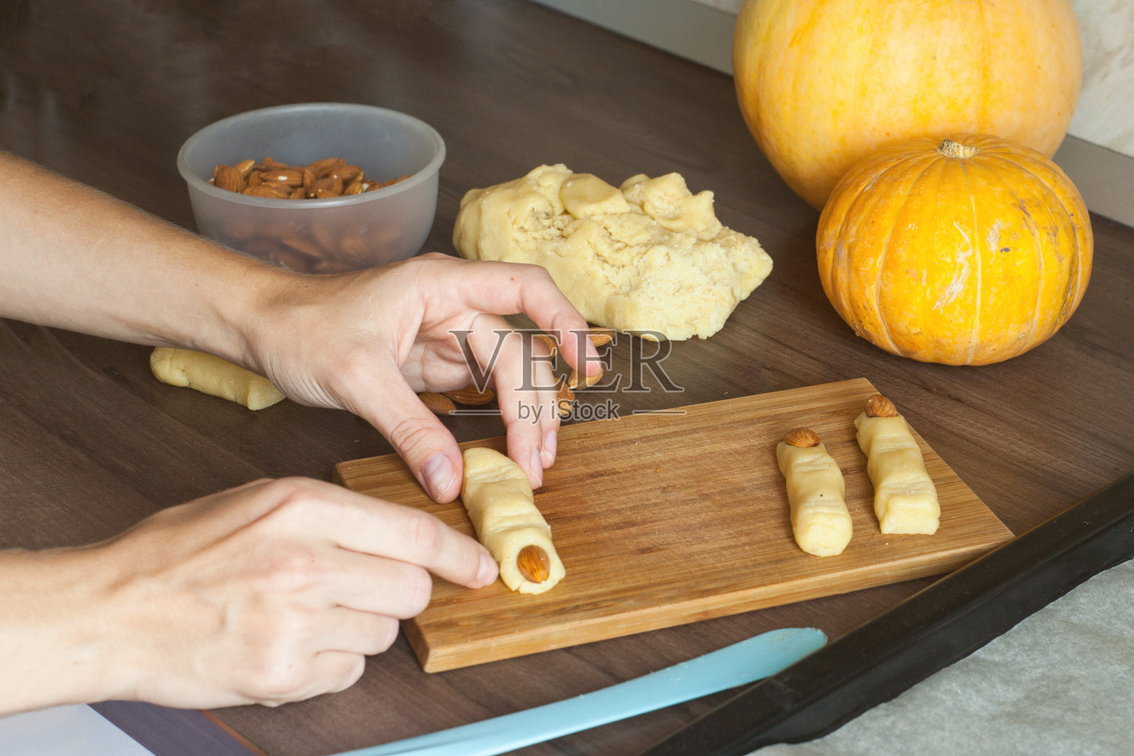 家庭主妇用她的手从厨房糕点成型的万圣节饼干。传统的秋天的节日。照片摄影图片