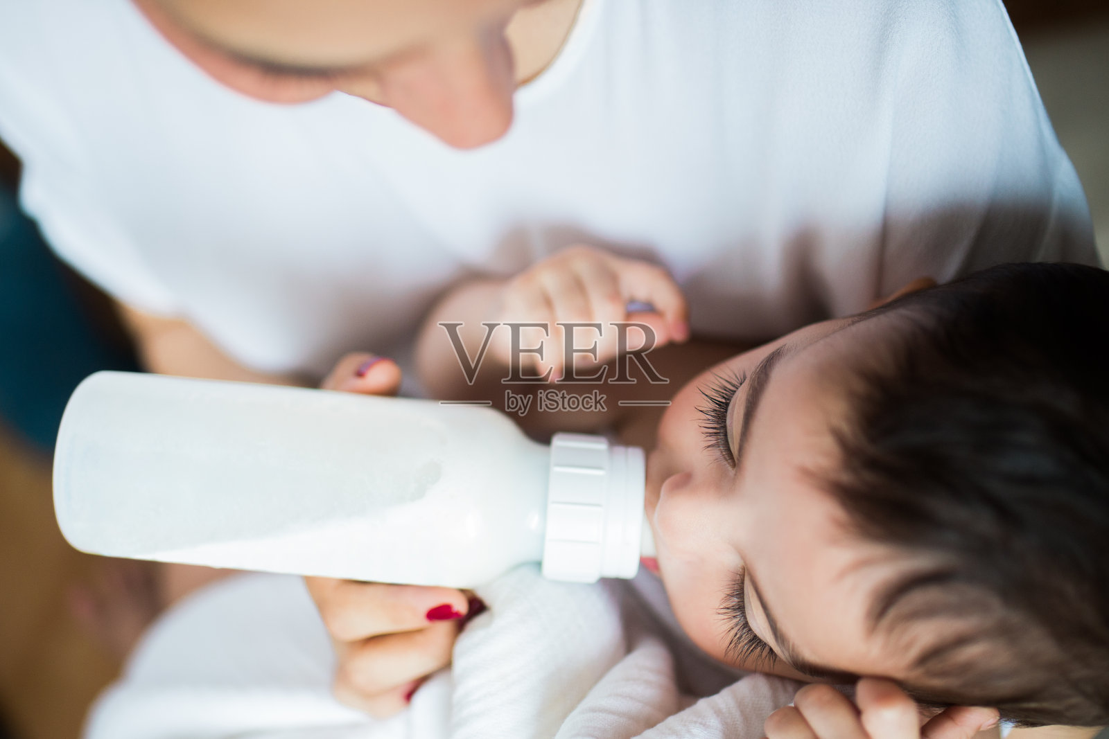 女婴从奶瓶中饮水的高角度视图照片摄影图片