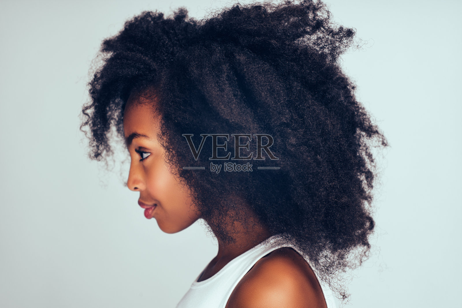 一个可爱的卷发非洲小女孩的侧面照片摄影图片