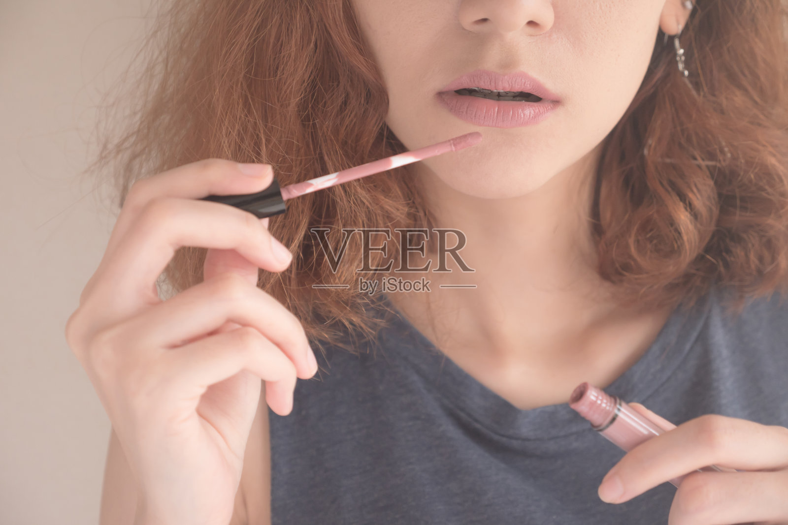 特写女孩使用液体口红或唇膏，唇部护理化妆品。照片摄影图片