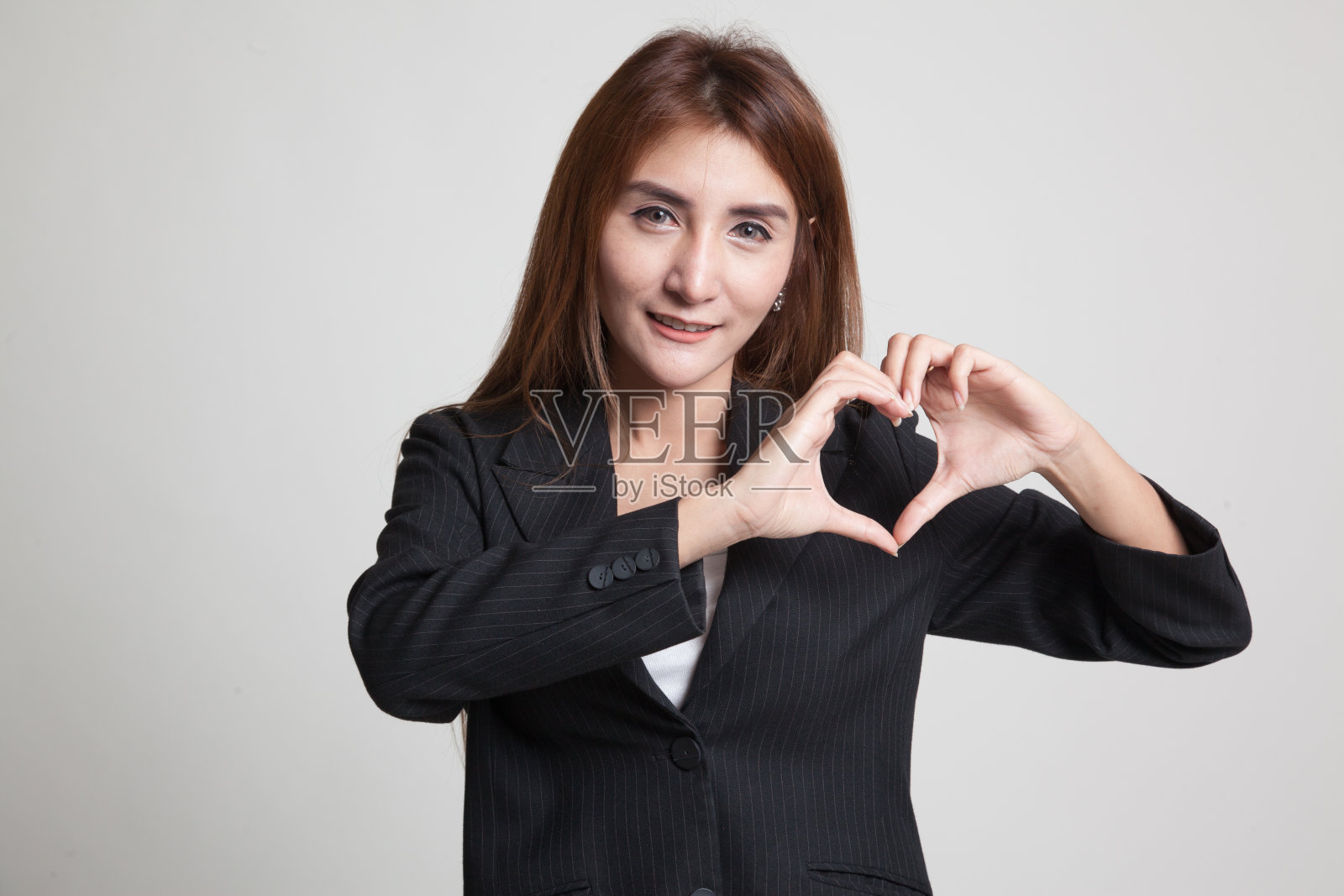 年轻的亚洲女子展示心形手势。照片摄影图片