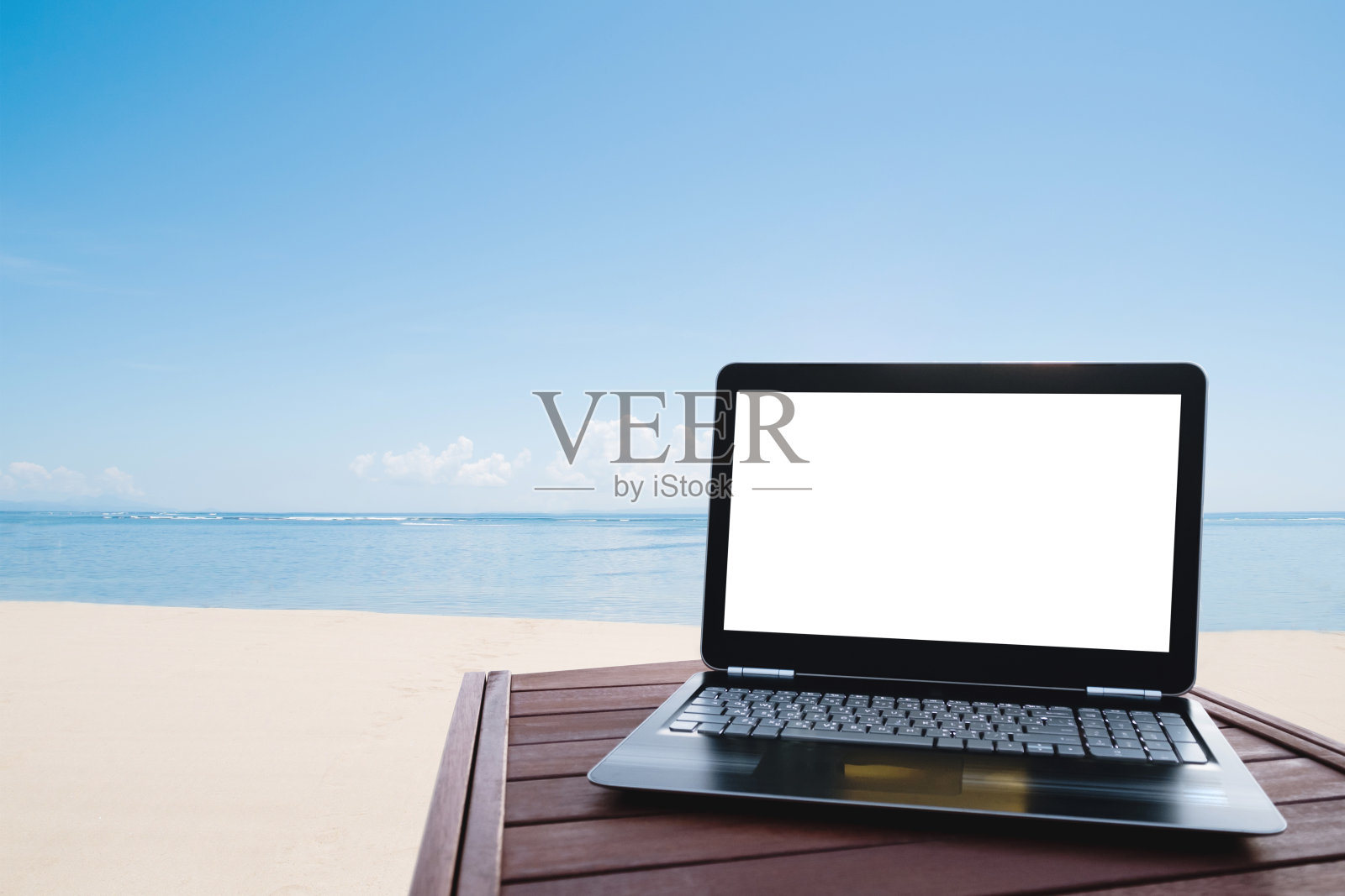 夏天，在海滩的木桌上放笔记本电脑照片摄影图片
