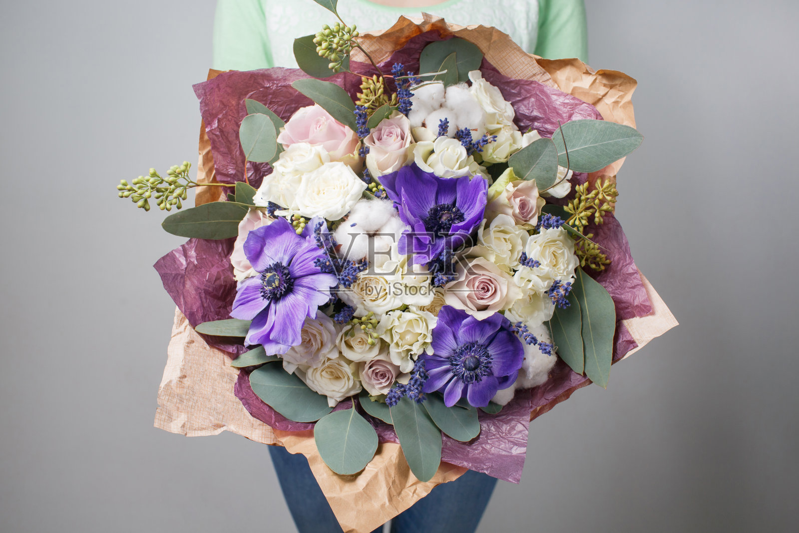 丰富的花束，不同颜色的花朵混合在女人手里。照片摄影图片