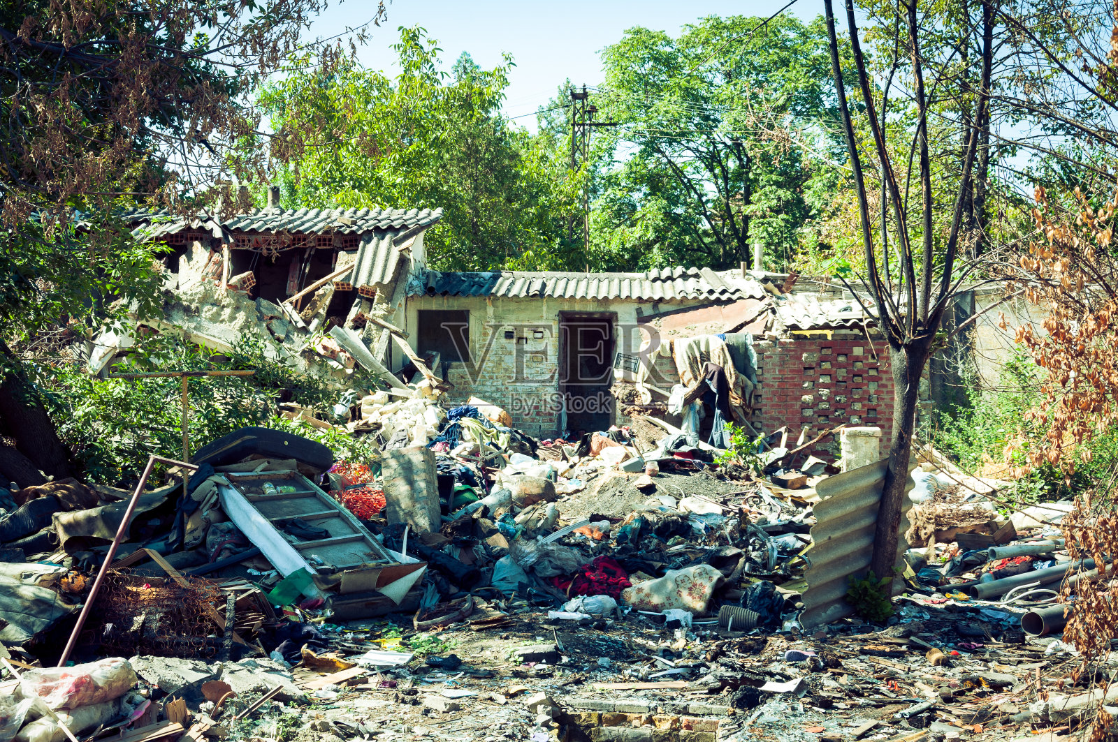 炸弹爆炸后被遗弃的房屋废墟，废墟散落在院子里照片摄影图片