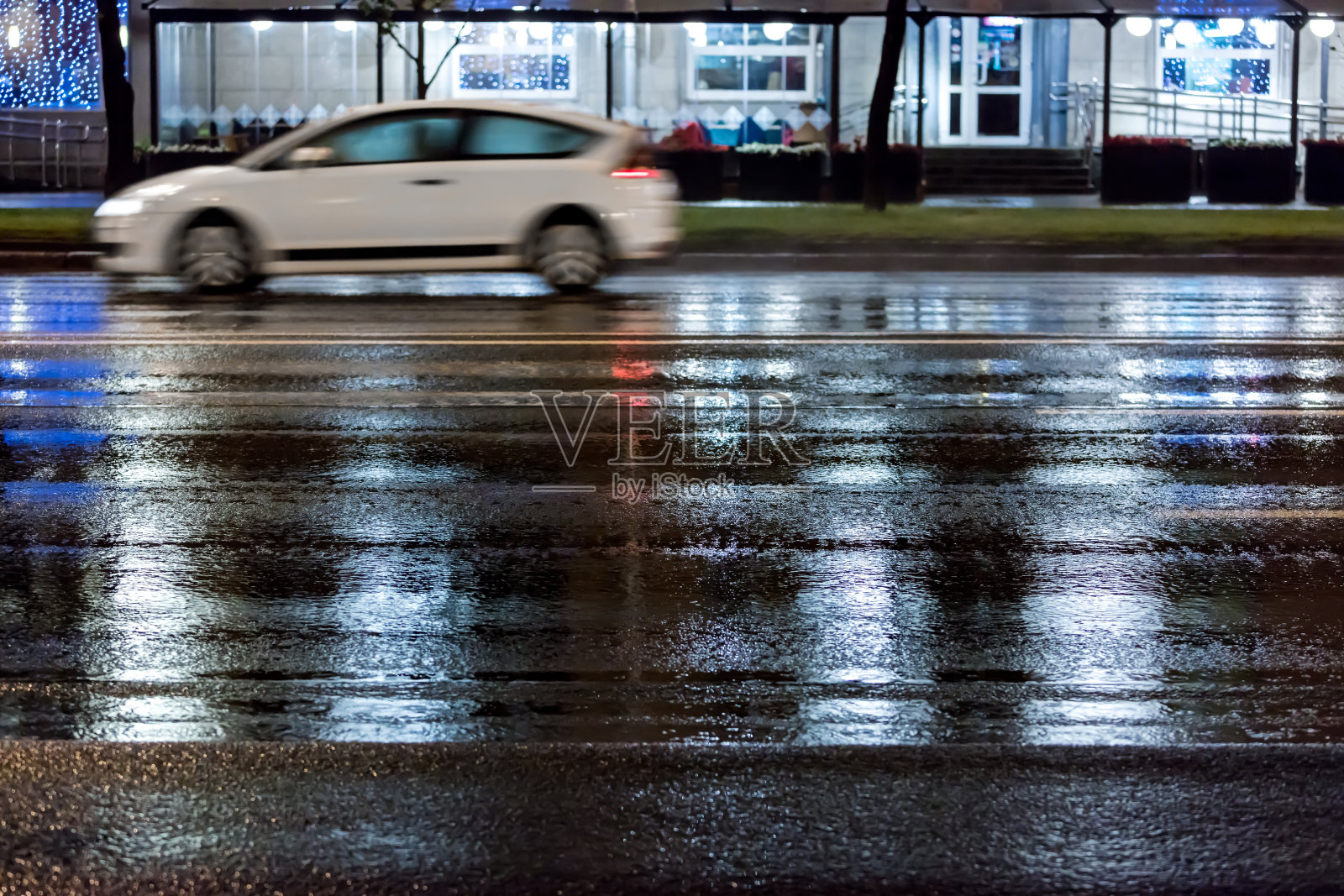 雨夜，模糊的汽车在城市街道潮湿的道路上行驶照片摄影图片