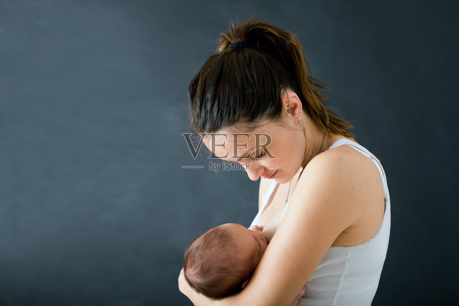 年轻的母亲正在母乳喂养刚出生的男婴照片摄影图片