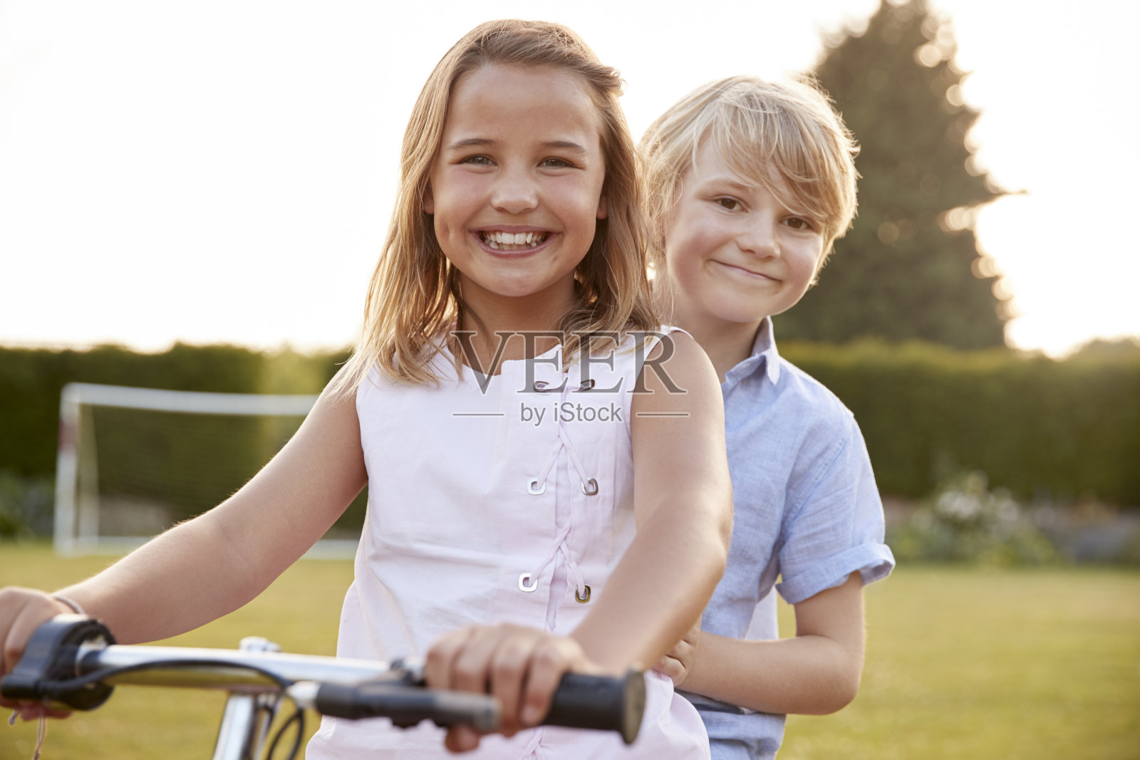 两个孩子在花园里骑自行车照片摄影图片