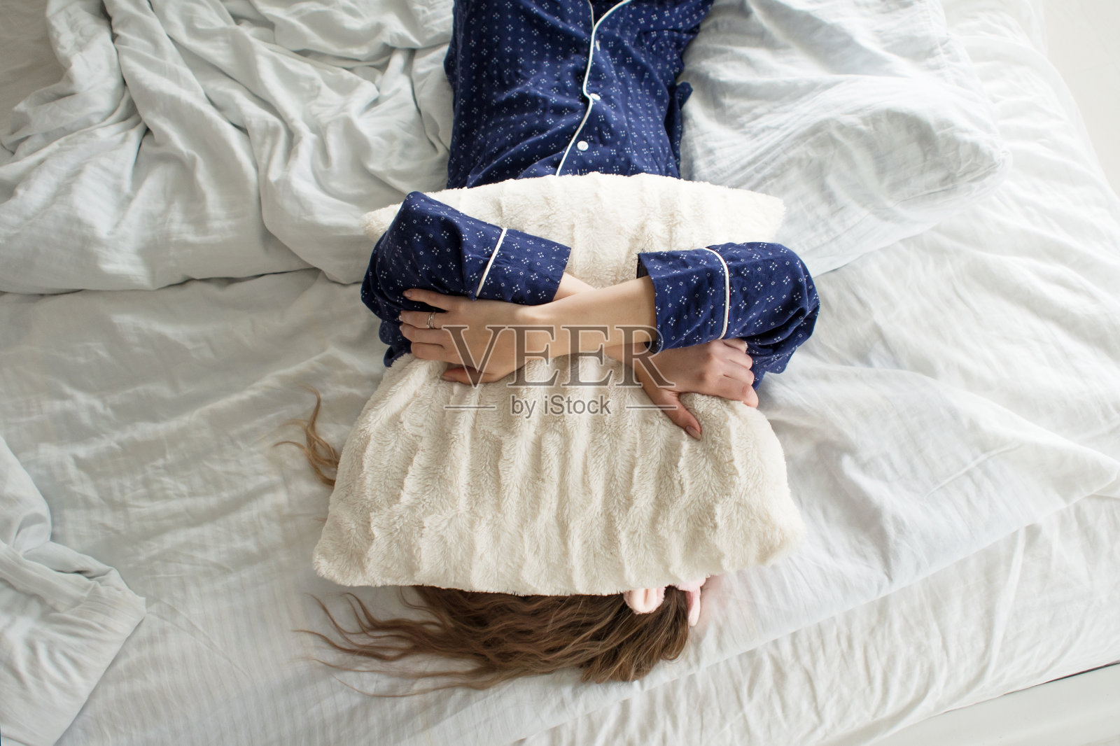 懒得下床，一个女人用枕头捂着脸照片摄影图片