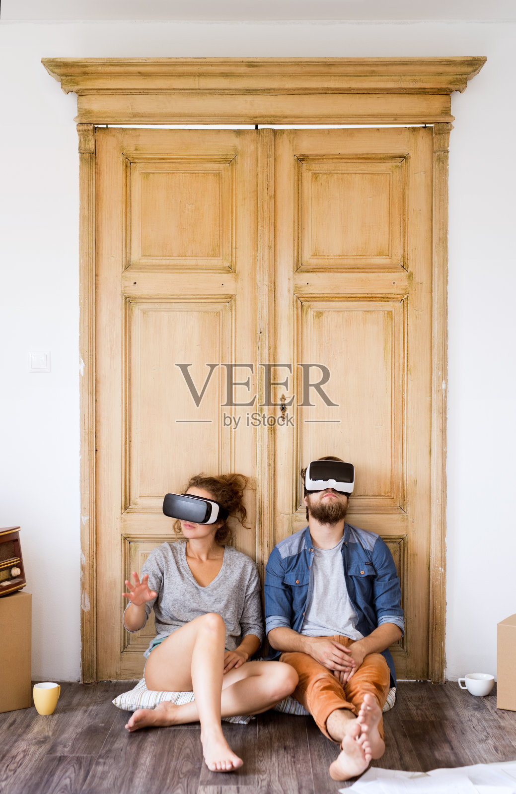 一对年轻夫妇戴着VR眼镜搬进新家。照片摄影图片