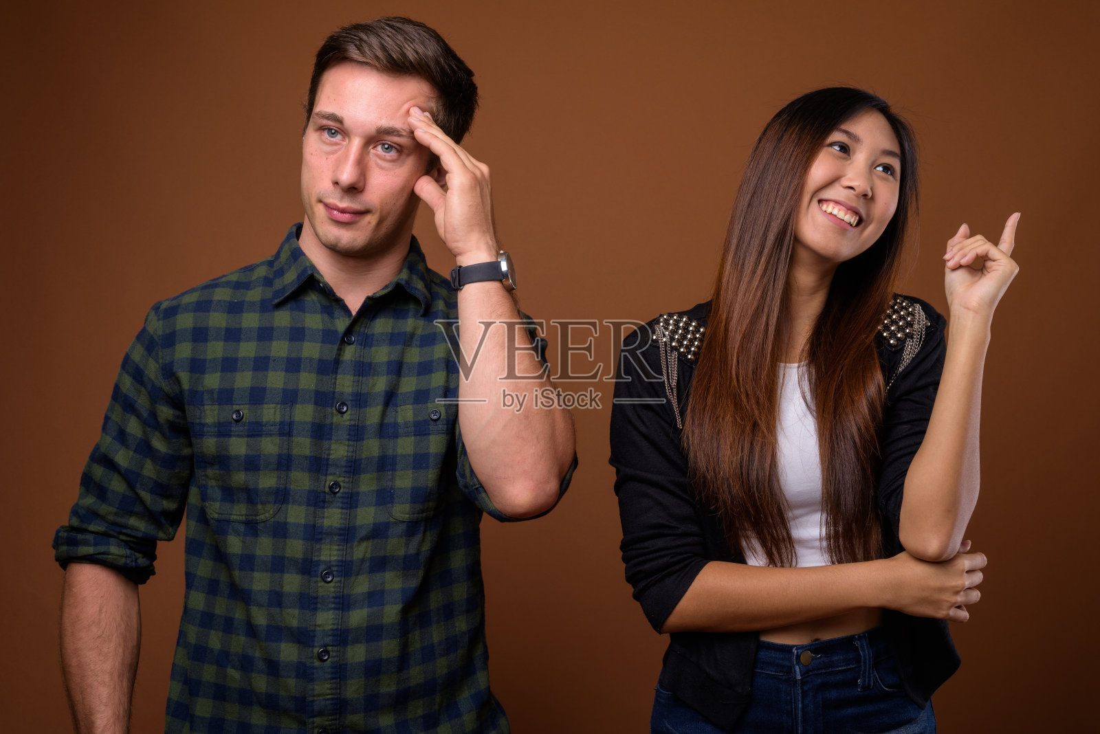 工作室拍摄的年轻英俊的男子和年轻美丽的亚洲女子一起对彩色背景照片摄影图片
