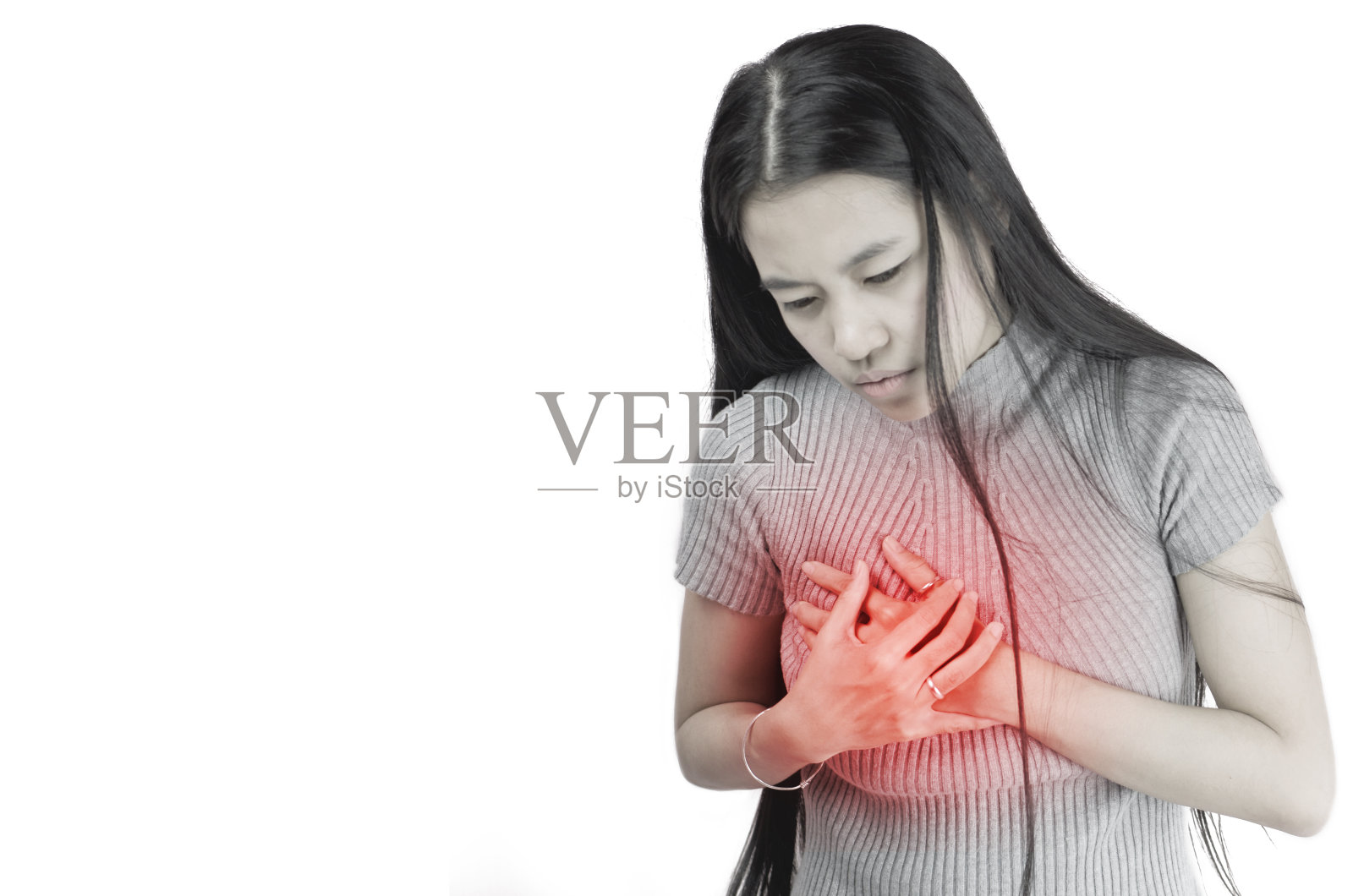 一个亚洲或泰国妇女的肖像，手触摸她的胸部在心脏和感觉严重的胸痛心脏病发作穿着灰色毛衣在白色的背景，深褐色的色调，健康的生活方式概念照片摄影图片