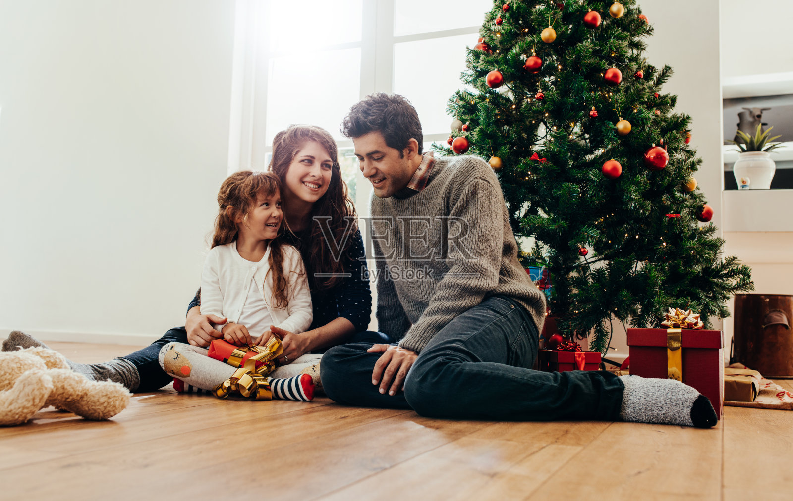 快乐的小家庭在家庆祝圣诞节。照片摄影图片
