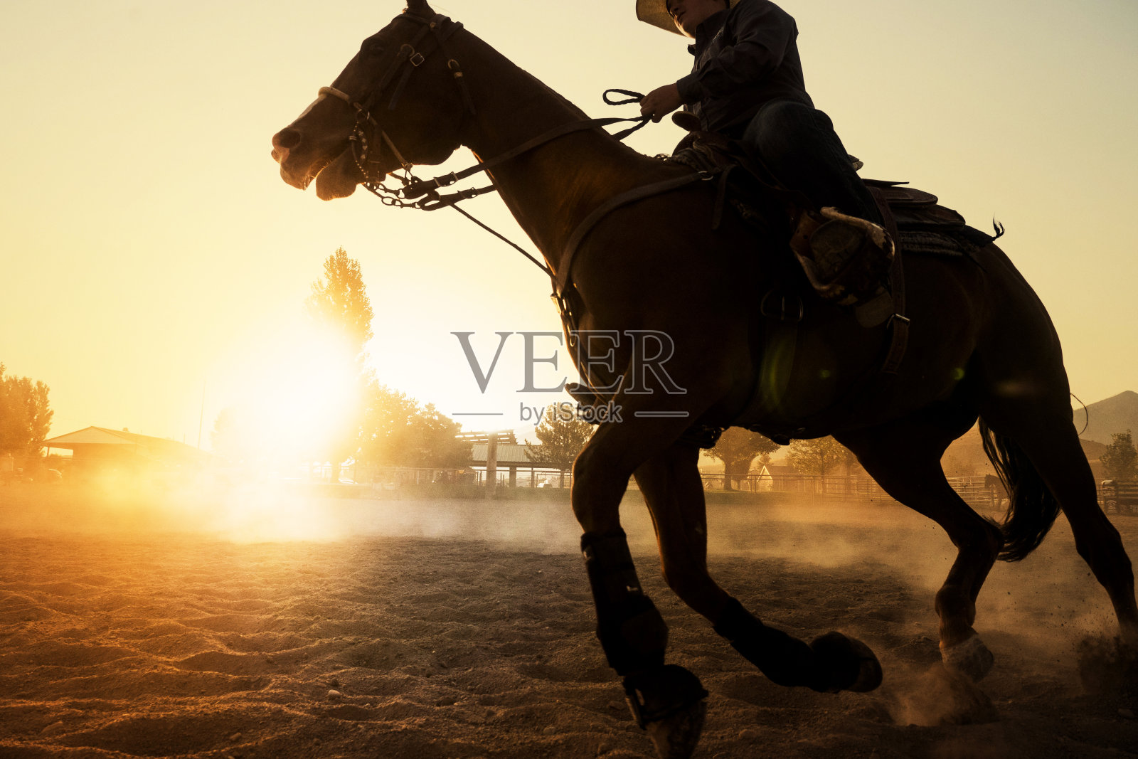 牛仔在日落时分骑马照片摄影图片