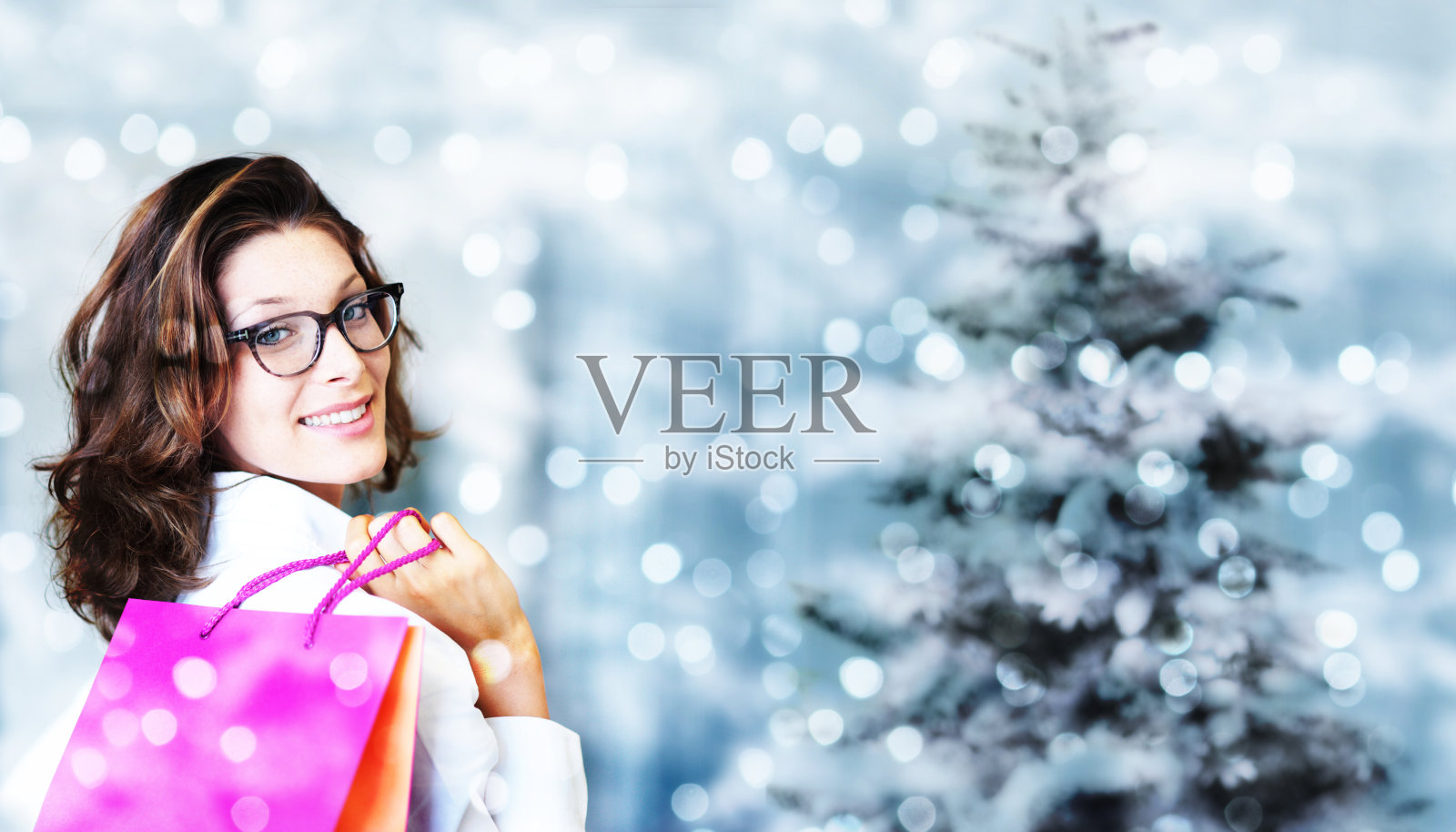 圣诞节购物，笑眯眯的女人拿着包包就模糊了亮丽照片摄影图片