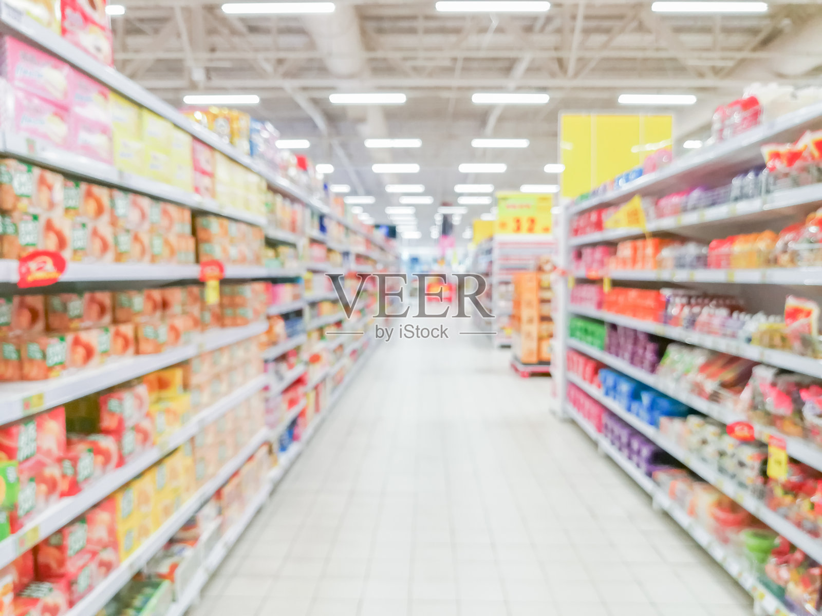 抽象模糊的超市通道，五颜六色的货架和难以辨认的顾客作为背景照片摄影图片