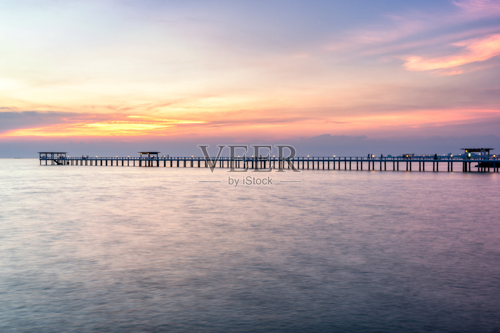 日落时海上的木桥照片摄影图片