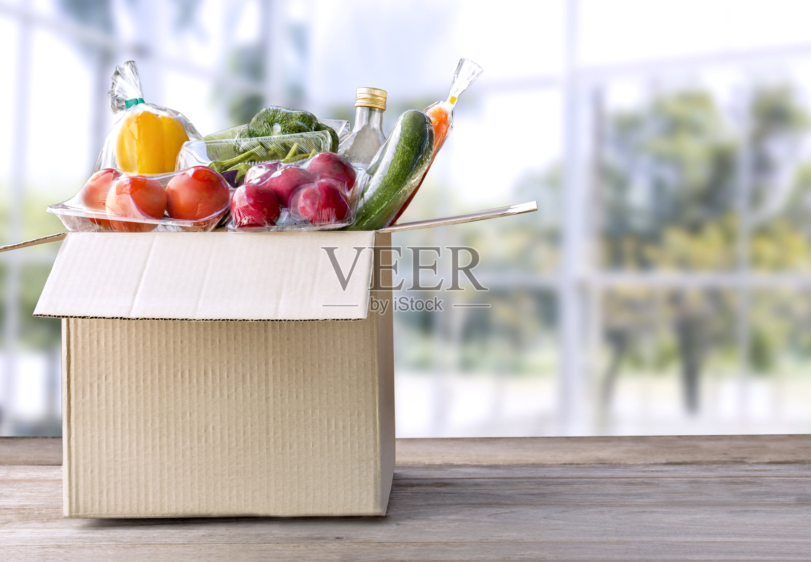 送餐服务:蔬菜上门送餐在线订做，包装盒为空白文字。在木制桌子的背景上。(剪切路径)照片摄影图片