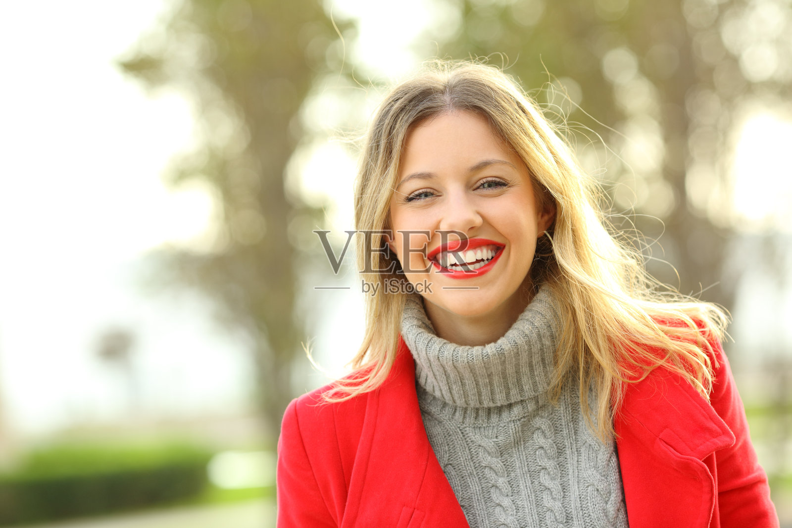 一个快乐的女人在冬天穿着红色夹克的肖像照片摄影图片