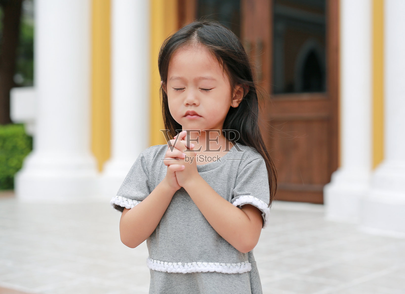 亚洲小女孩早上在花园里祈祷。小女孩手祈祷，双手合十祈祷的概念，信仰，灵性和宗教。照片摄影图片