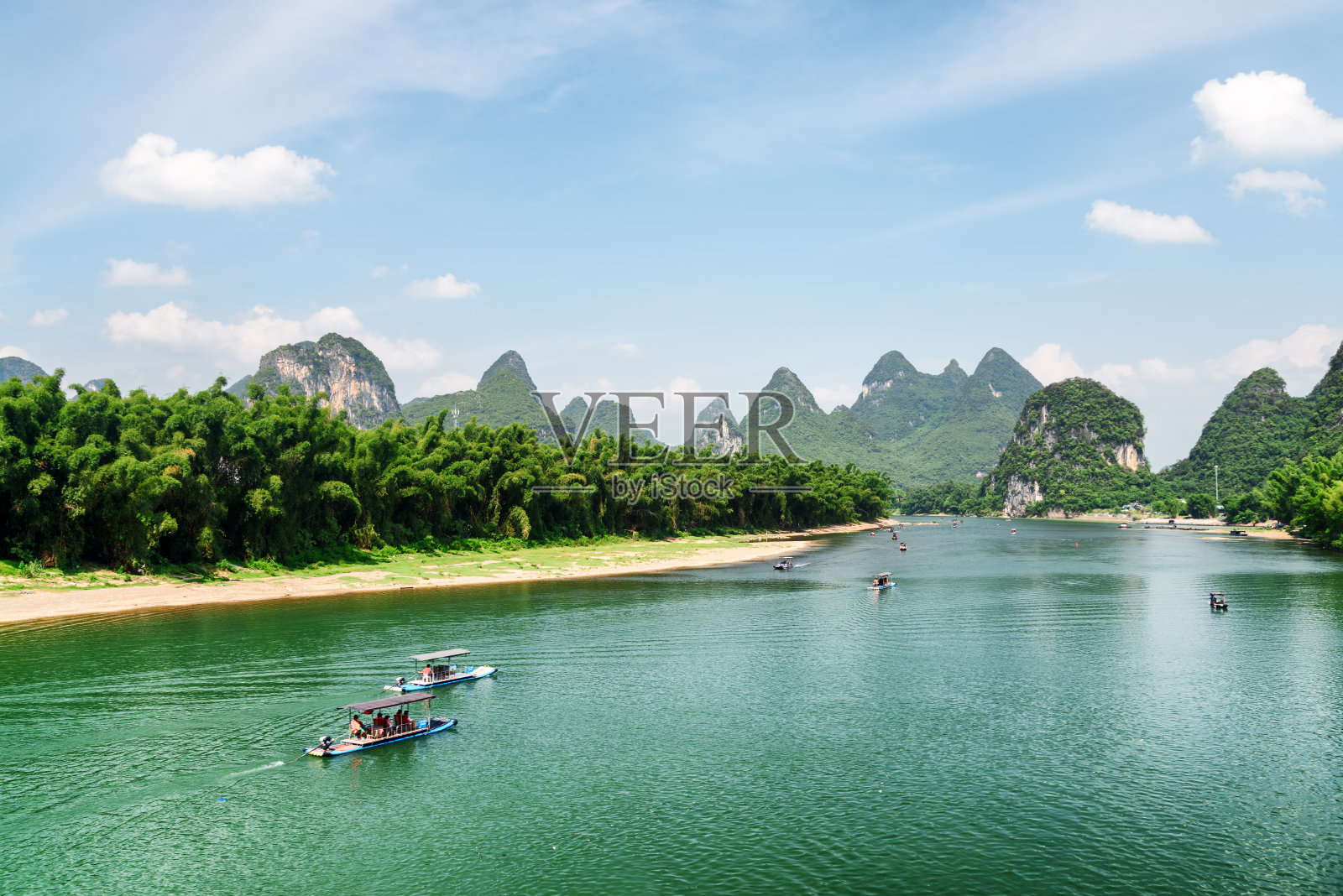 湛蓝的漓江上，游人驾驶着木筏照片摄影图片