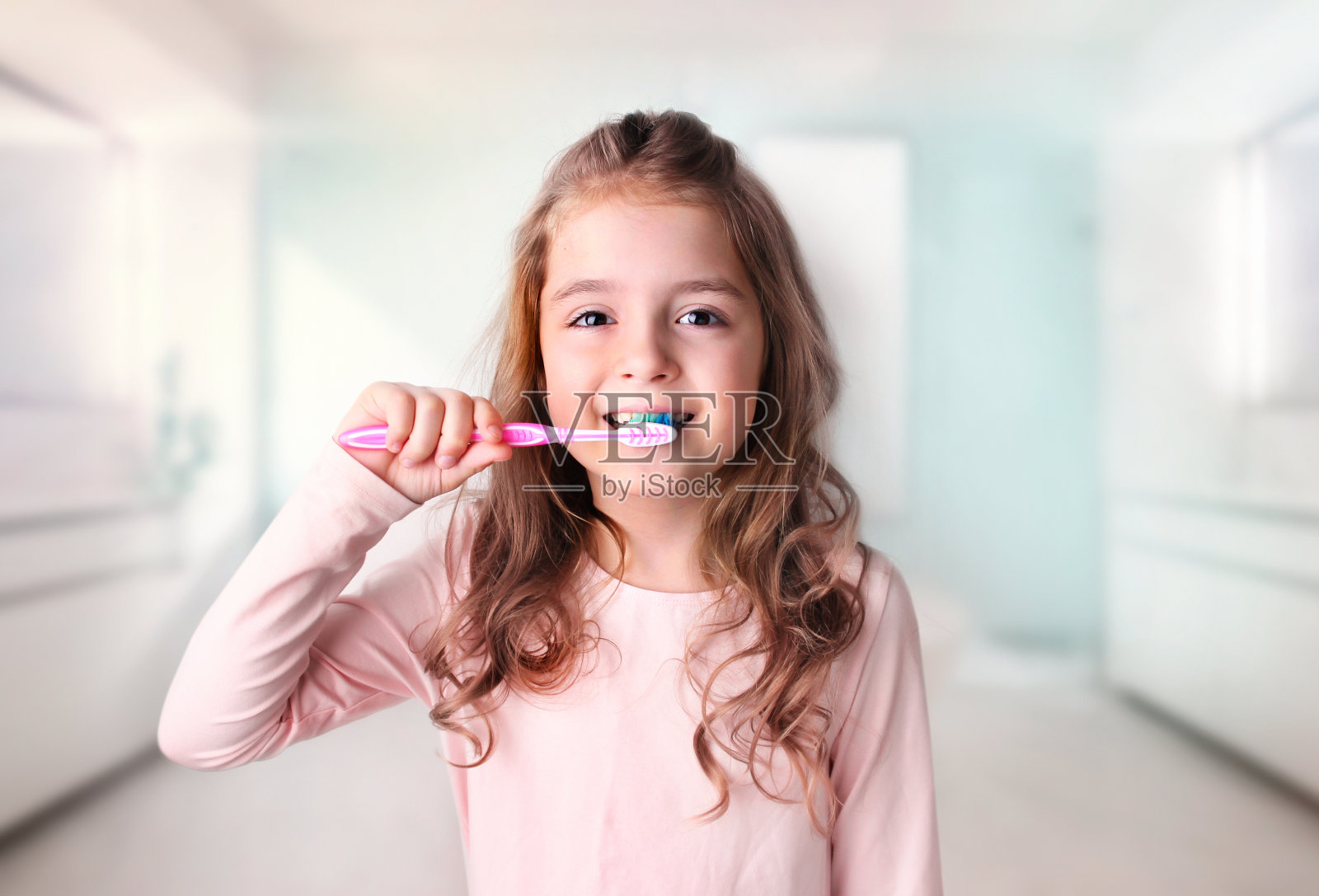 一个白人小女孩在浴室里刷牙。照片摄影图片