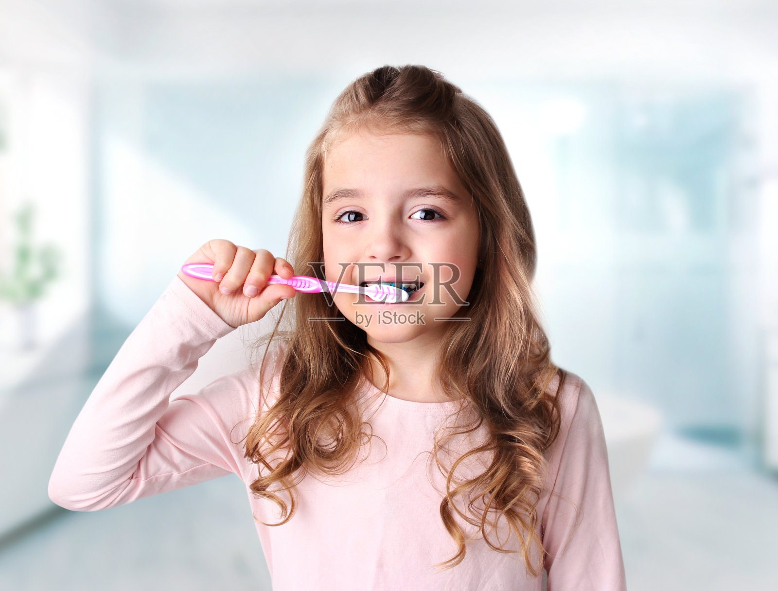 小女孩在浴室里刷牙。牙齿健康。照片摄影图片