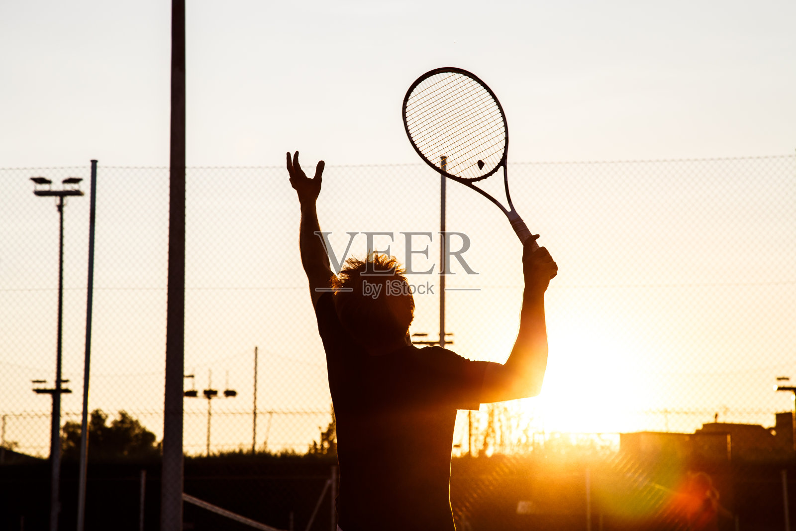 一个无名男子在球场上打网球照片摄影图片