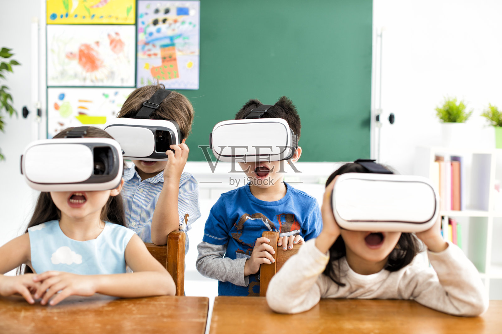 惊讶的学生用虚拟现实头盔在教室里照片摄影图片