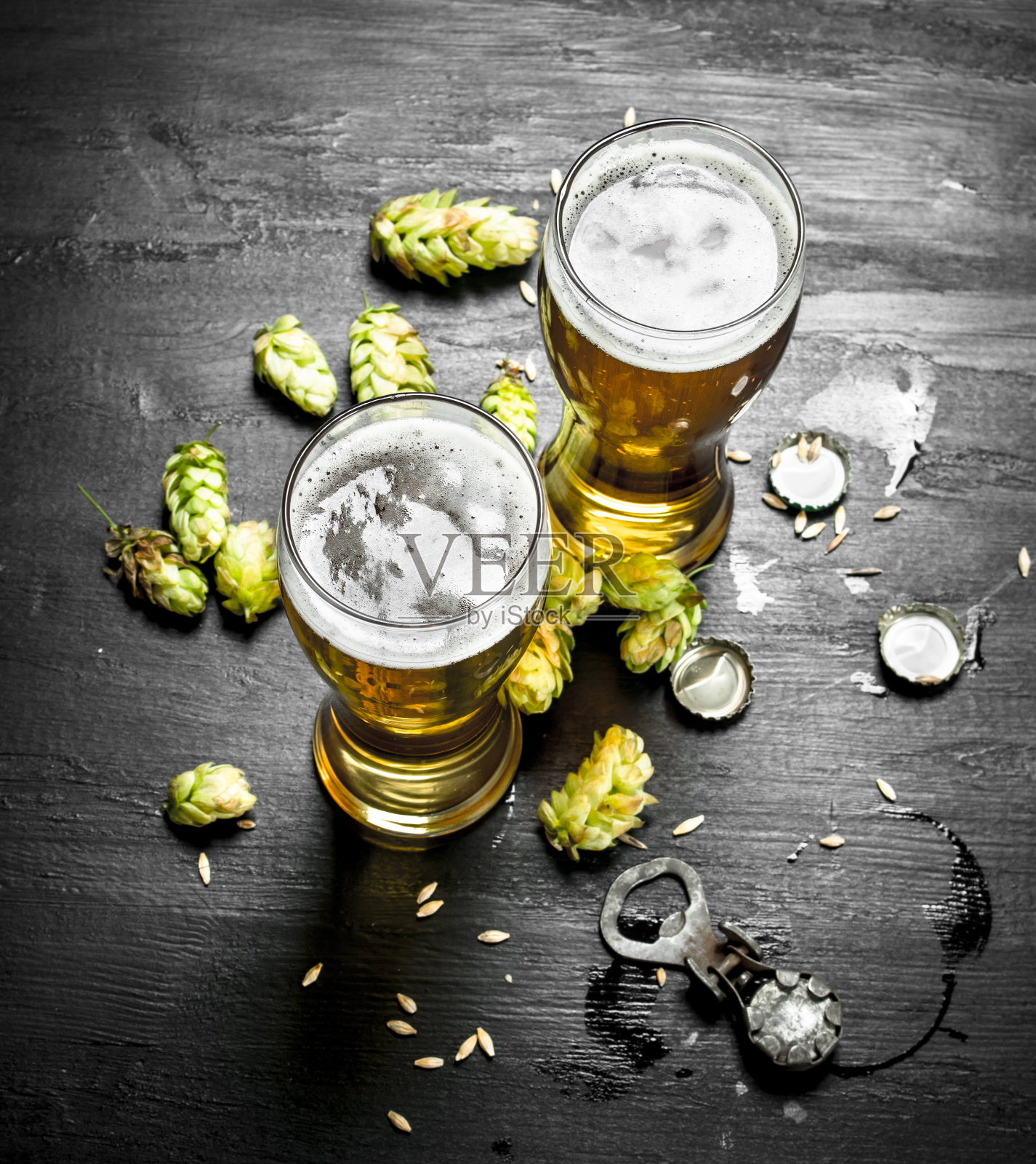 盛有啤酒和绿啤酒花的玻璃杯。照片摄影图片