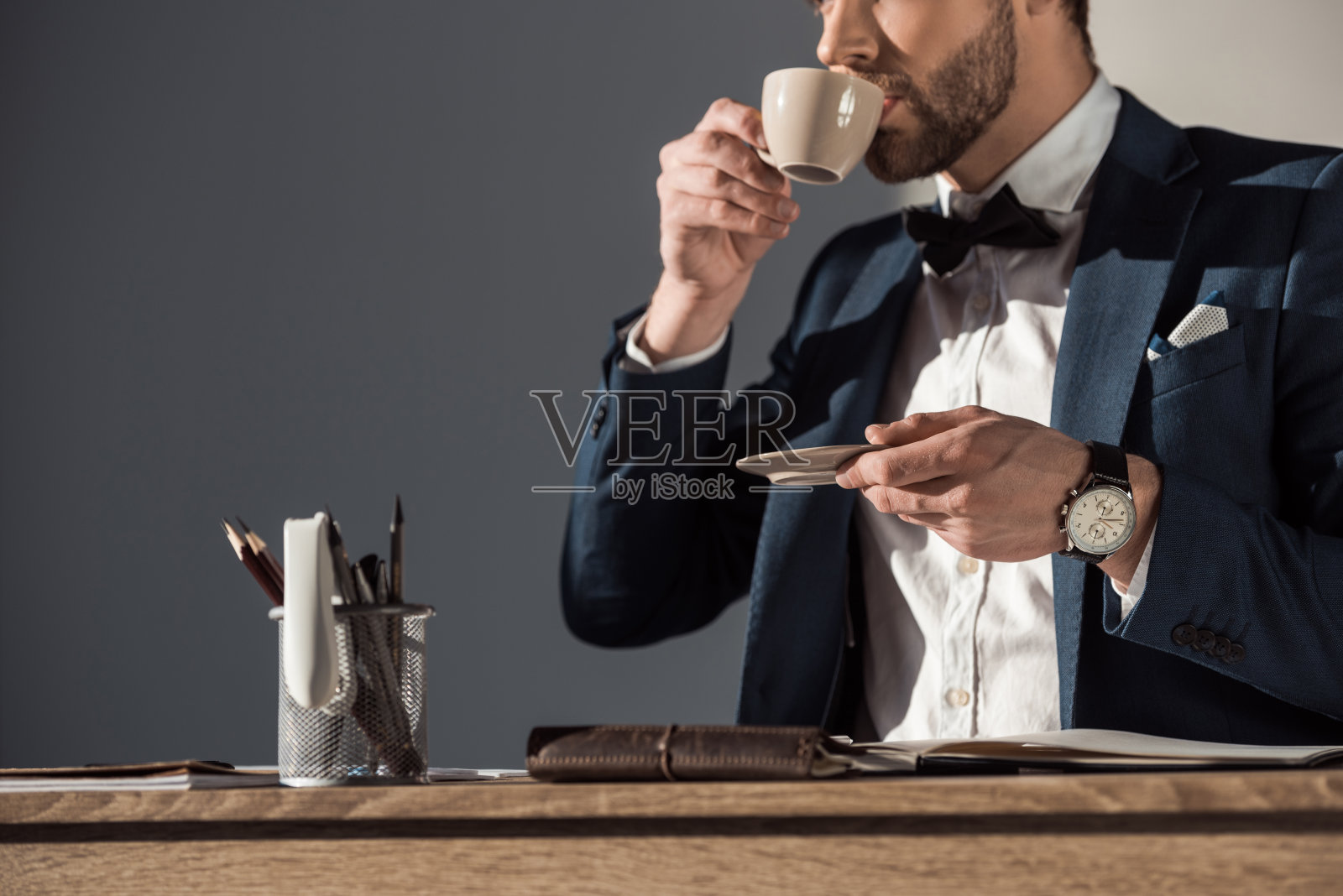 时尚的年轻商人在工作场所喝咖啡的镜头照片摄影图片