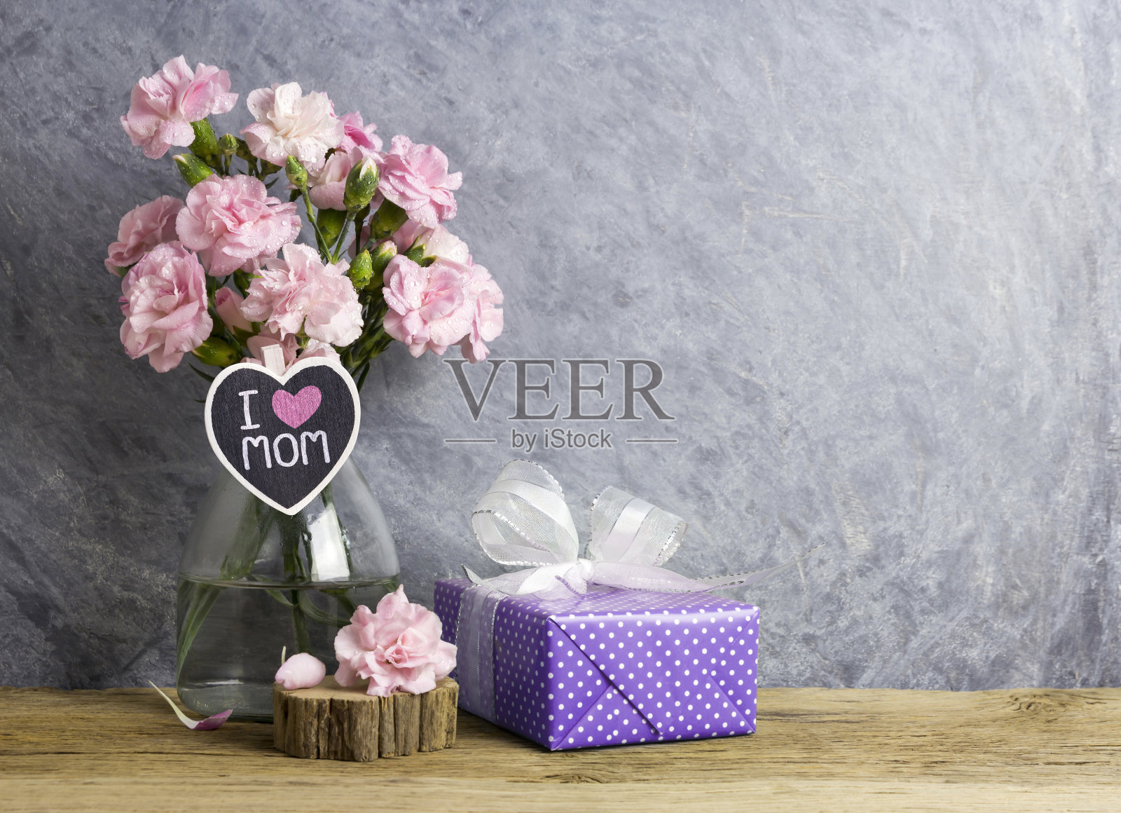 快乐母亲节的概念粉红色康乃馨花在瓶子上与我爱妈妈的心木和紫罗兰的礼物盒照片摄影图片