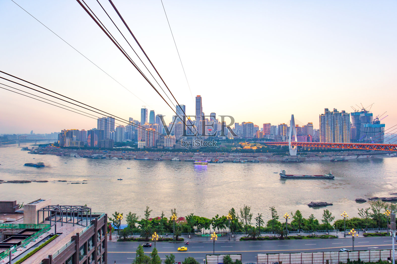 钢缆横跨河流和现代城市景观照片摄影图片