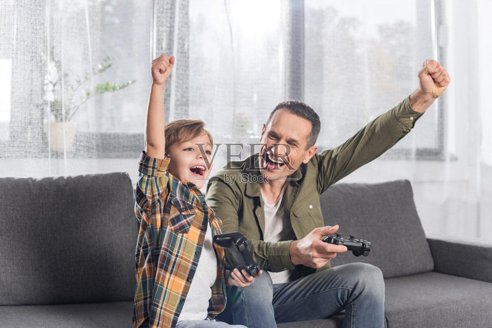 父亲和儿子在玩电子游戏照片摄影图片