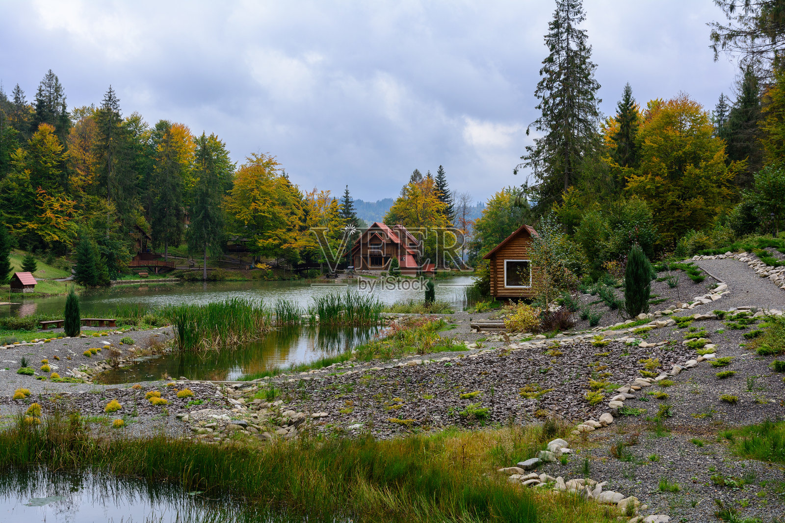 房子在湖边的森林里，秋日。落叶的风景。照片摄影图片