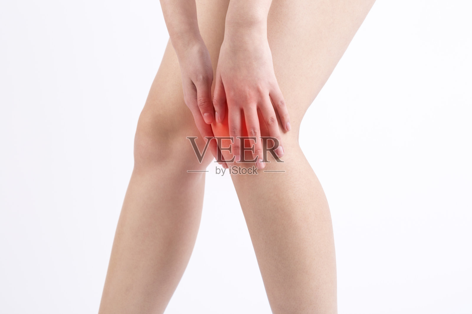 膝盖疼痛的女人。红点。照片摄影图片