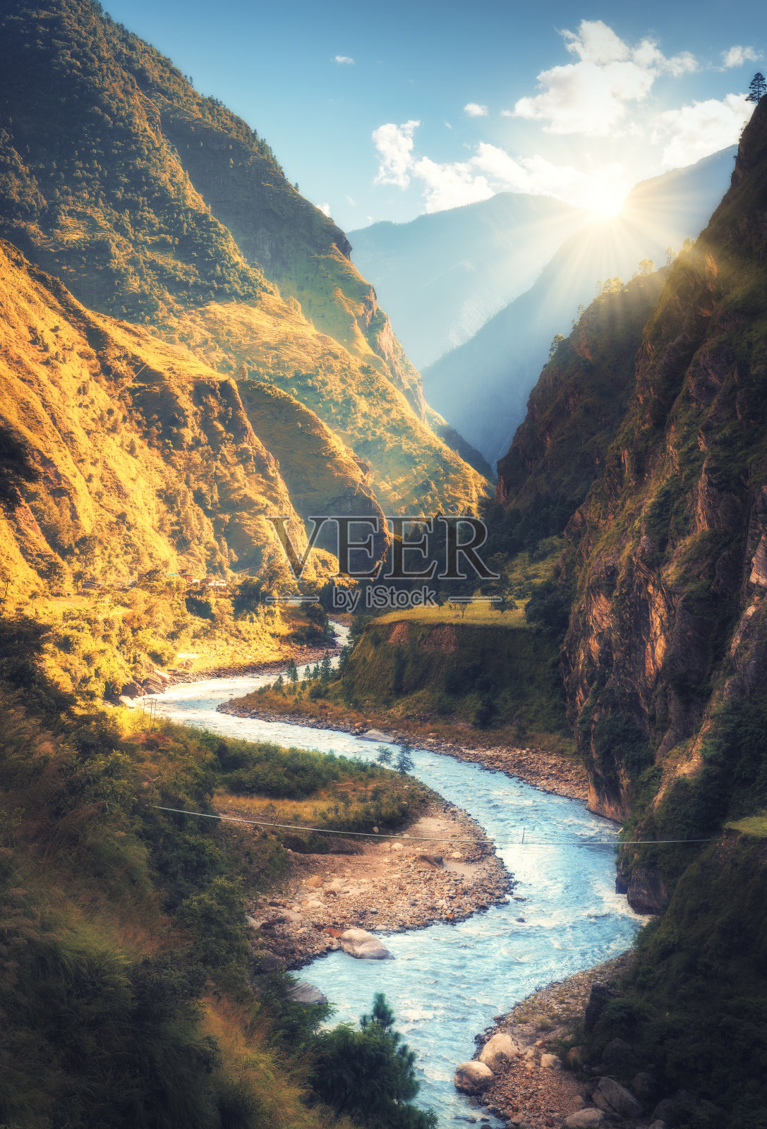 高喜马拉雅山脉，美丽弯曲的河流，绿色的森林，蓝天白云和黄色的阳光在秋天日落在尼泊尔。山谷。在喜马拉雅山脉旅行照片摄影图片