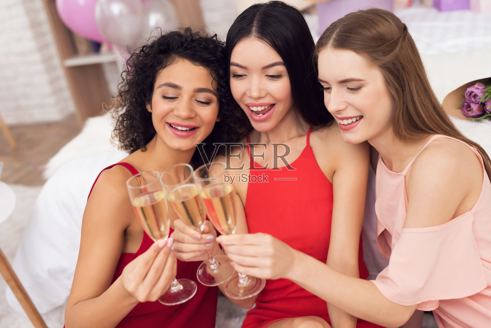 三个拿着香槟杯的女孩。他们正在庆祝3月8日的妇女节。照片摄影图片