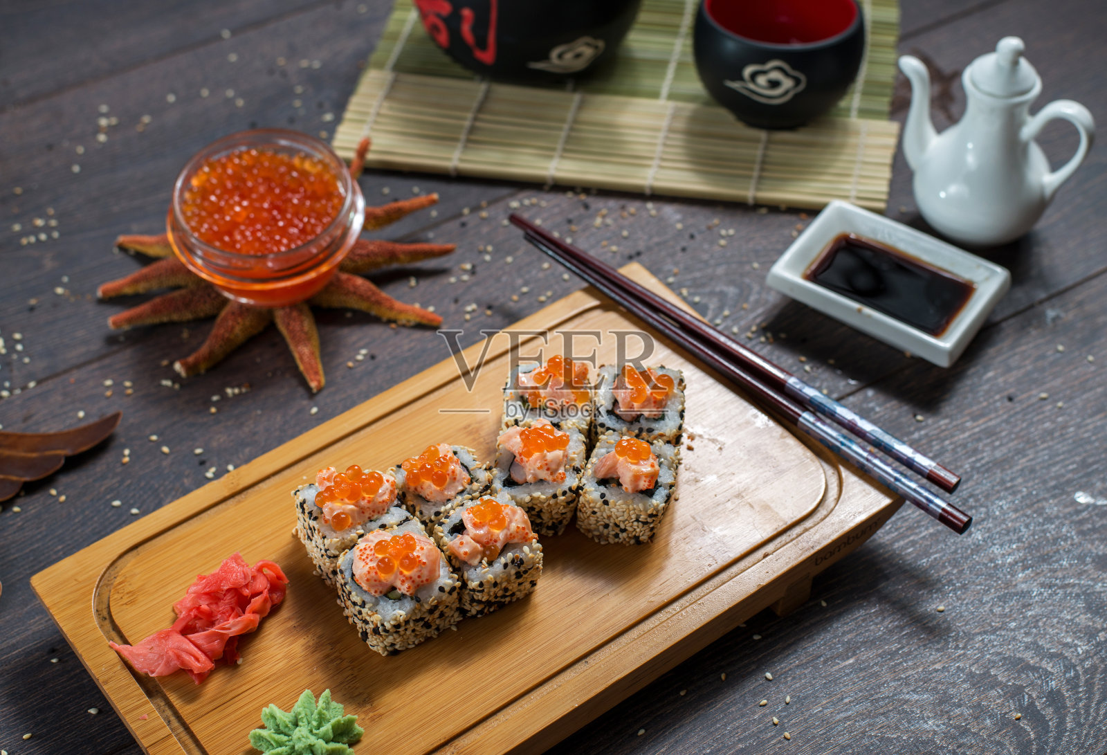 寿司卷和鱼子酱放在黑色的木桌上。日本的食物。照片摄影图片