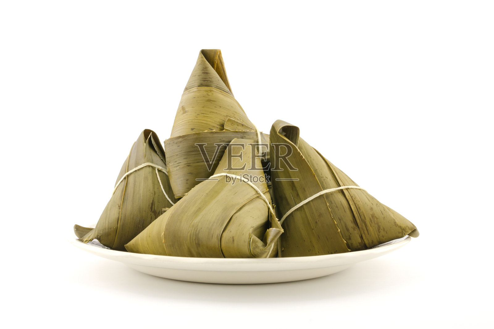 传统的粽子或粽子包在盘子上，孤立在白色的背景上照片摄影图片