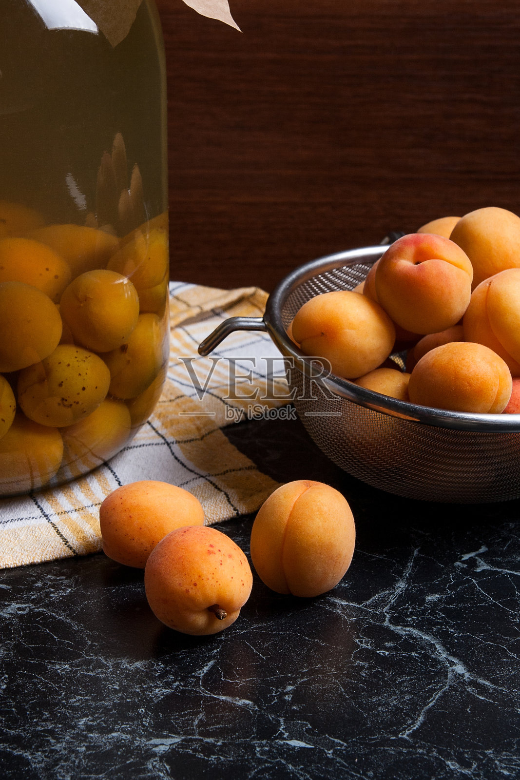 收获的杏子在钢滤器和罐装果盘照片摄影图片
